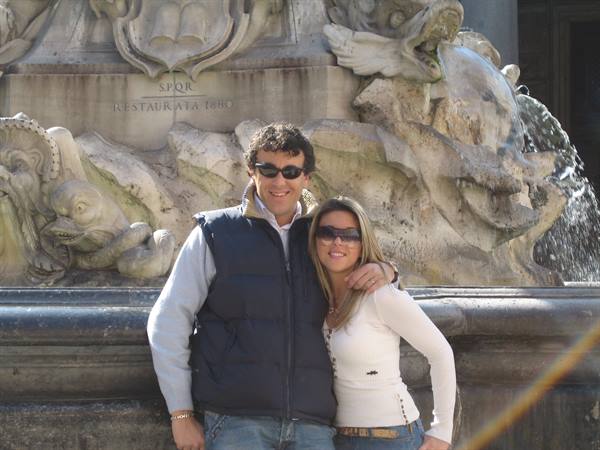 Couple in sunglasses by the Pantheon fountain with marble dolphins and SPQR inscription