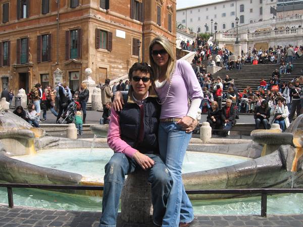 Smiling couple in front of the Barcaccia fountain at Rome's Spanish Steps