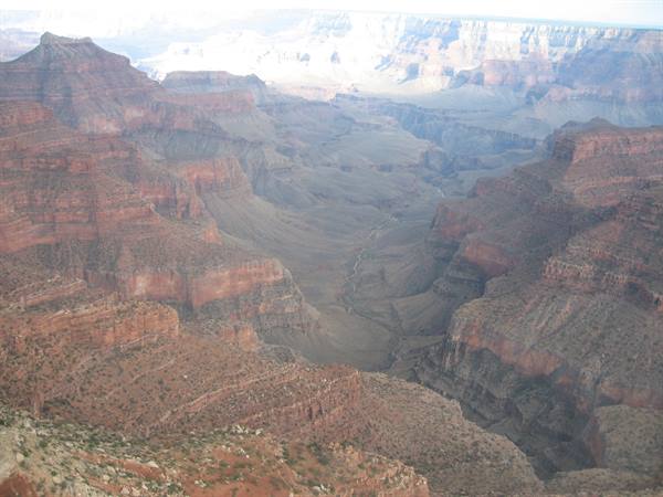 Layered red rock walls of the Grand Canyon under hazy light