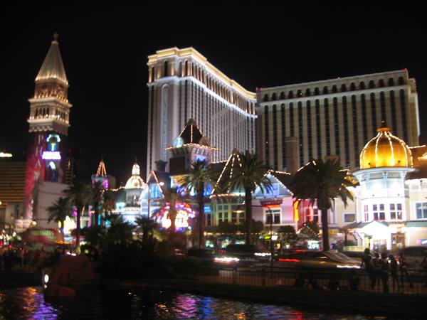 Night shot of the Venetian in Las Vegas: lit bell tower and hotel reflecting on water