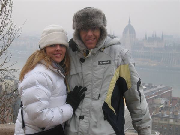 Couple in winter jackets before the Danube and Budapest Parliament in the fog