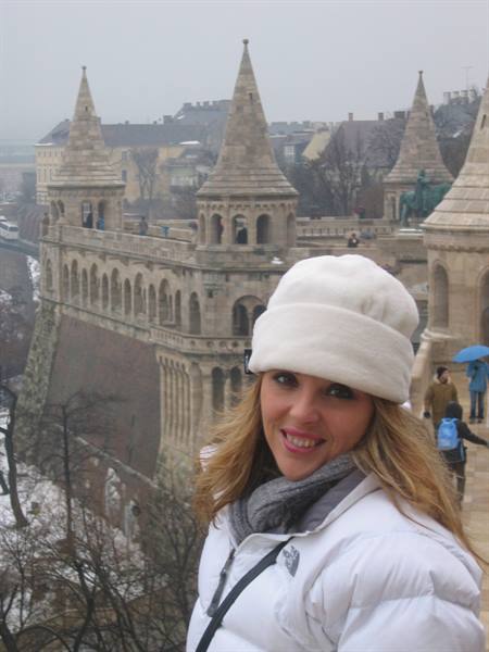 Woman in white hat in front of Fisherman's Bastion in Budapest, grey winter day