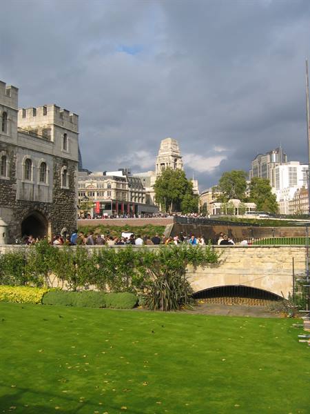 Tourists queuing in front of a stone fortress under a cloudy sky