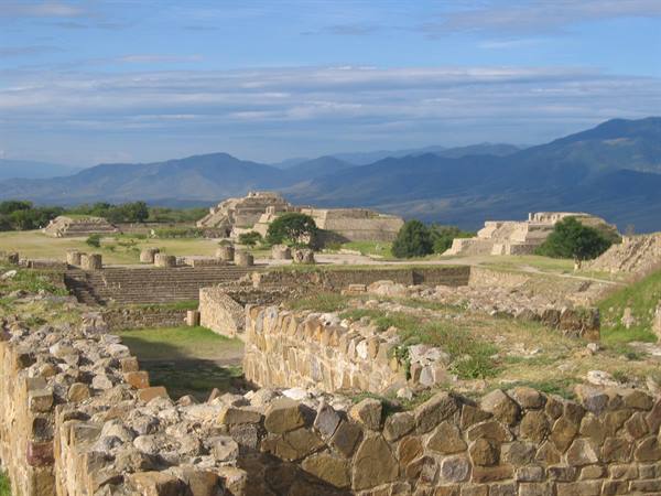 stone ruins and pyramids of Monte Albán among mountains and green grass
