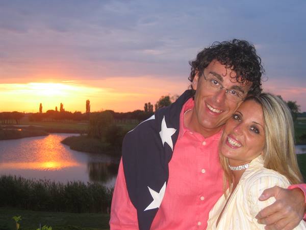 Smiling couple hugging by the lake, golden light on the water