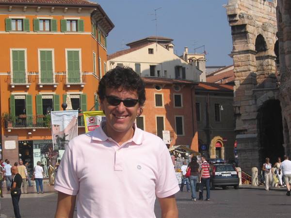 Smiling man in sunglasses in front of Verona Arena