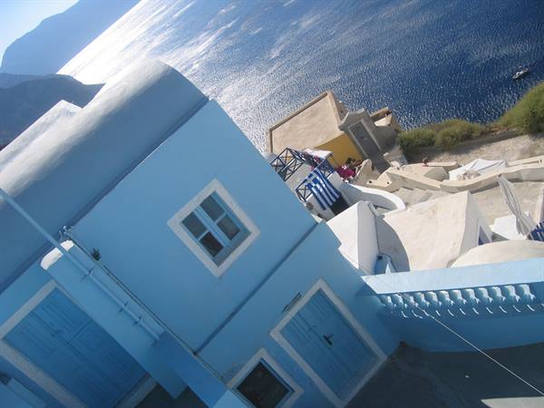 Blue house and whitewashed walls above the sea in Oia, Santorini
