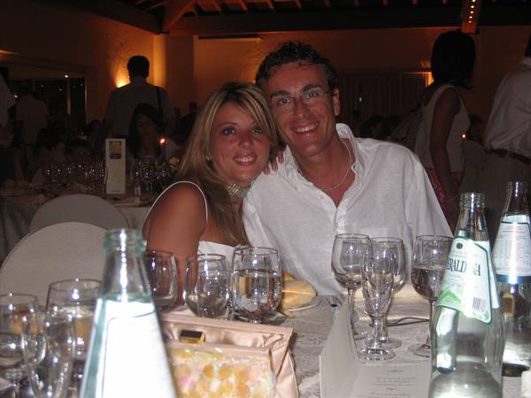 Smiling couple at a banquet table, wine glasses and San Pellegrino bottles