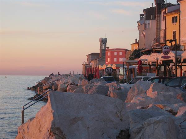 White rocks and colored houses at dusk on Piran's waterfront