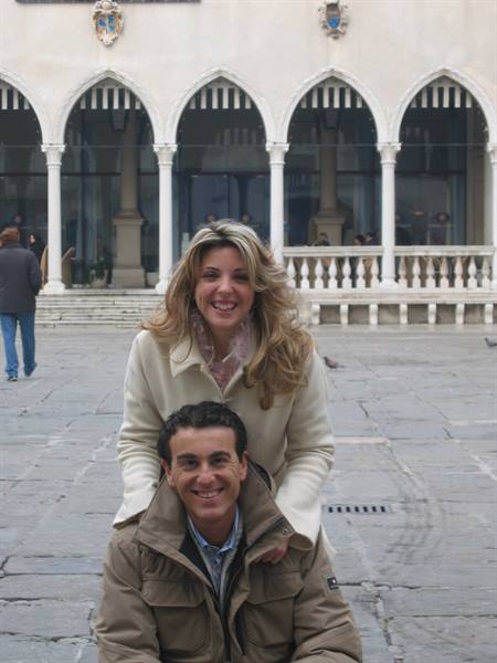 Smiling couple in front of the Gothic arcades of Doge's Palace, Venice