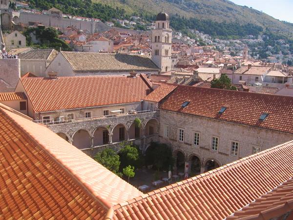 Cloister with arches and orange tiled roofs, bell tower, Dubrovnik