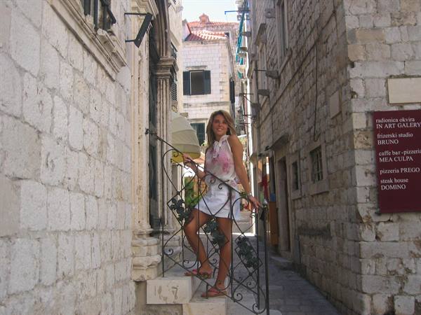 Woman in white dress on stone stairs in Dubrovnik old alley