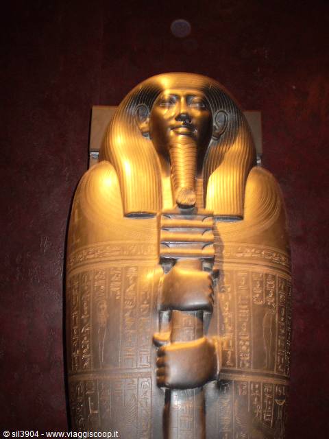Golden sarcophagus of Pharaoh Tutankhamun with engraved hieroglyphs under warm light
