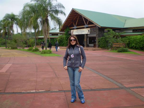 Woman in sunglasses at the Iguazú visitor center, red pavement and palm trees