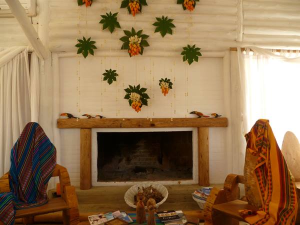 Wooden fireplace in a lodge hall with leaf and flower decorations on white wall