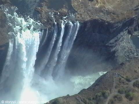 Victoria Falls: Zambezi water plunges into rocky gorge, white mist rising