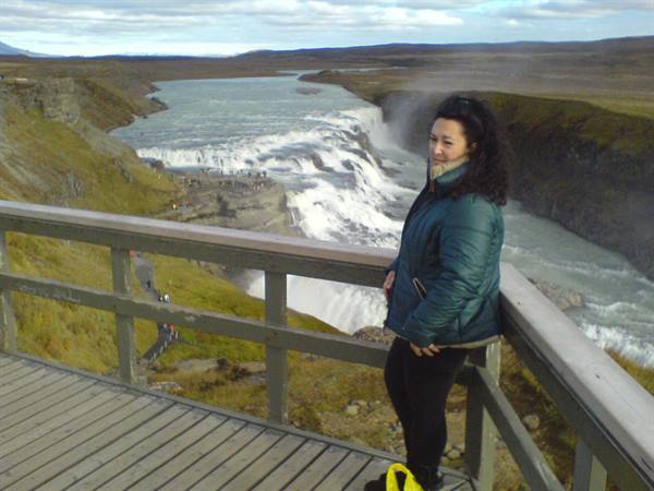 Woman on wooden platform in front of Gullfoss waterfall