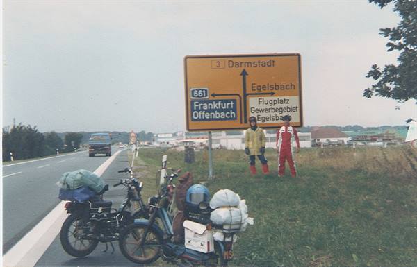 Loaded motorbikes beside the road sign pointing to Frankfurt and Darmstadt