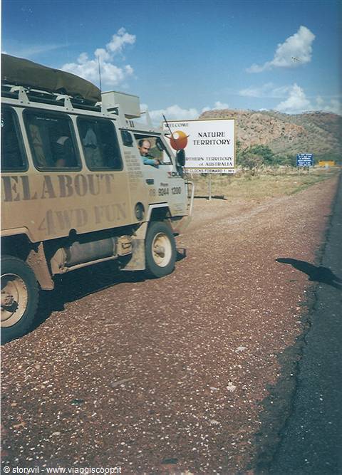 4WD truck stops at the welcome sign to Northern Territory