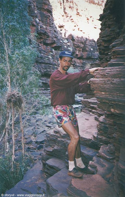 Hiking among the layered red rocks of Karijini, in natural light on stone steps