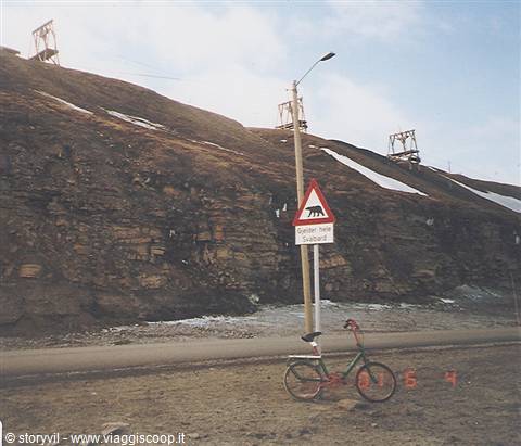 Polar bear warning road sign beside a parked bicycle, Longyearbyen