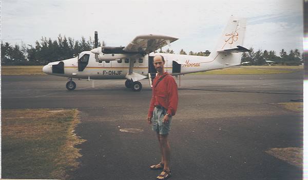 Man in red shirt in front of an Air Moorea F-OHJF twin-engine plane