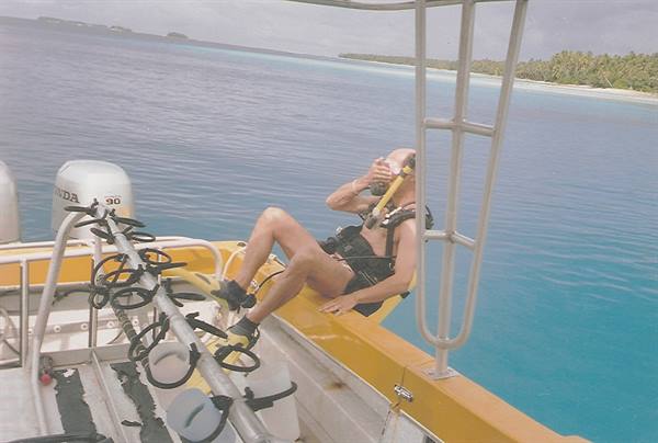 Scuba diver gearing up on the boat near the turquoise lagoon