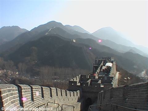 The brick Great Wall of China winds down between hazy mountains