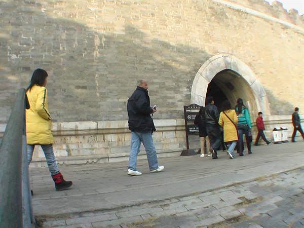 Tourists walk past the arched stone gate of Xi'an ancient city wall