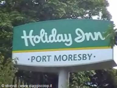 Green Holiday Inn hotel sign in Port Moresby surrounded by trees