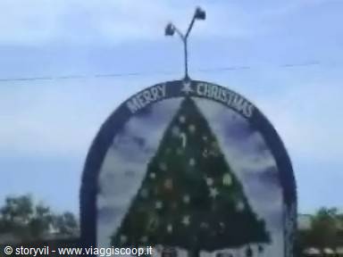 Merry Christmas sign with painted tree, blue sky and streetlights on top