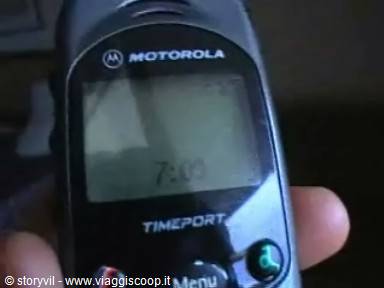 Motorola Timeport phone in hand, clock screen, dim light