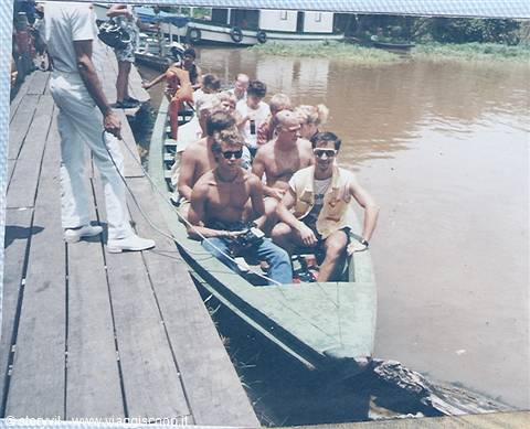 Tourists in a canoe moored at a wooden pier on the Amazon river