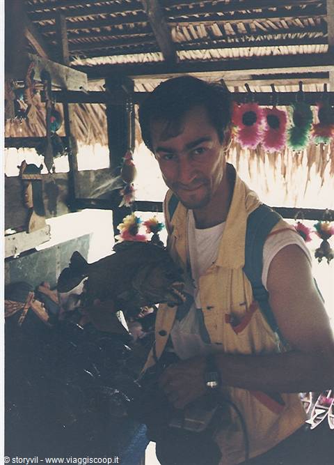 Smiling tourist holds a wooden fish under thatched roof