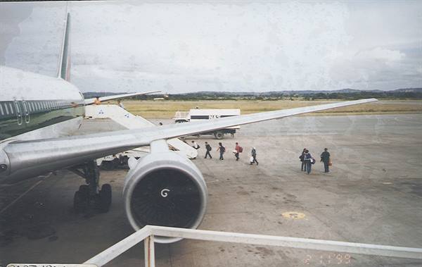 Passengers boarding a plane via airstairs on the airport tarmac