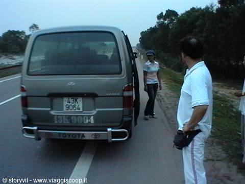 Tourist standing by a broken-down Toyota van on a rural road