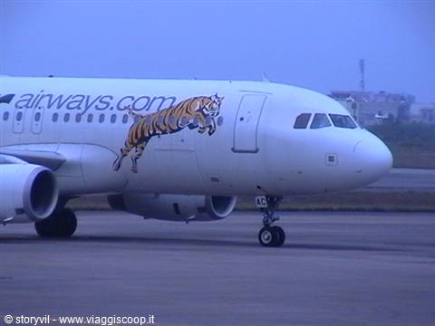 White airliner with painted tiger on fuselage taxiing on the runway