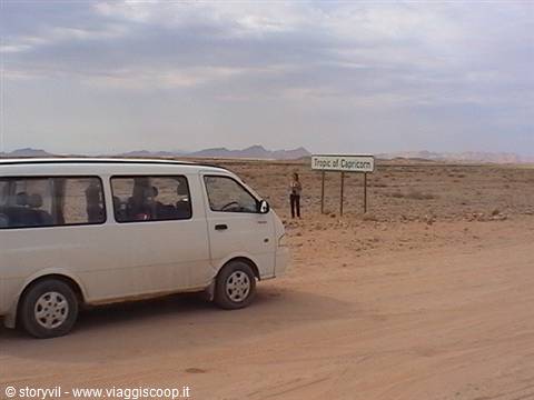 White van beside the Tropic of Capricorn sign in the desert