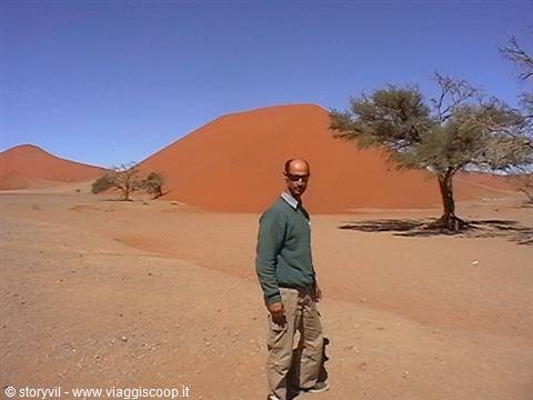 Man in green sweater in front of Sossusvlei red dunes