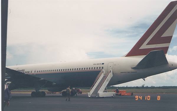 Martinair Boeing parked with boarding stairs, cloudy sky, ground crew, October 1994