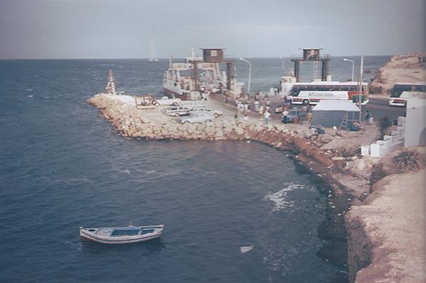 Ferry docked at Cirkewwa pier, buses and boats in the Maltese sea