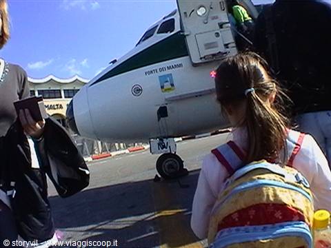 Little girl with backpack boarding a Meridiana plane at Malta airport