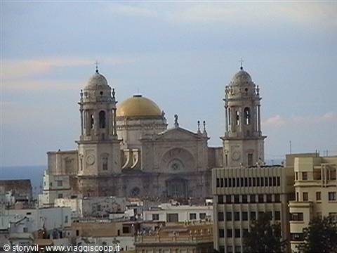Cádiz cathedral with golden dome and twin bell towers above city buildings