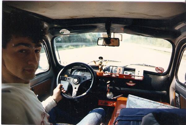Young man driving a Fiat 500, vinyl interior, daylight through the windshield