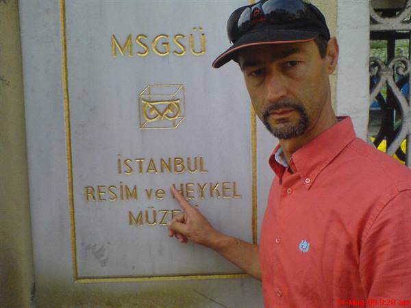 Man in cap pointing at the marble plaque of Istanbul Resim ve Heykel Museum