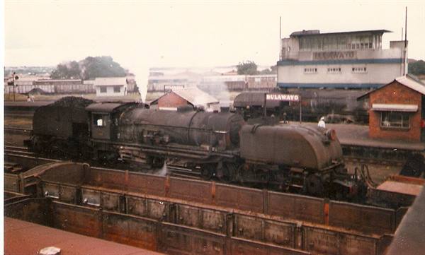 Steam locomotive beside wagons at Bulawayo railway station