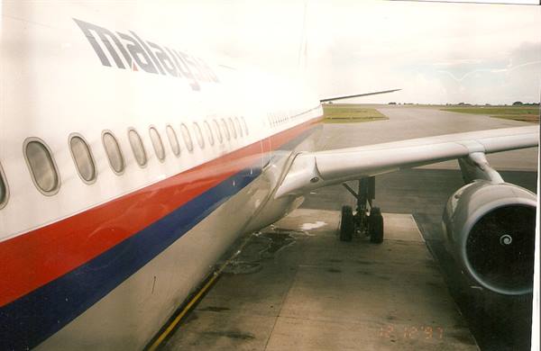 Malaysia Airlines Boeing on the apron, wing and engine seen from window