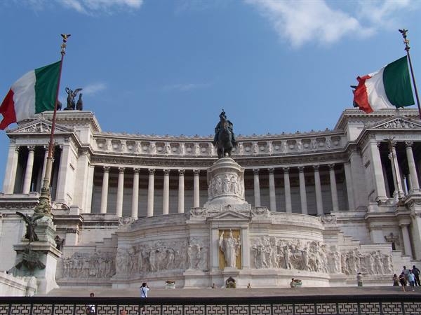 Vittoriano monument in Rome: white marble, statues, Italian flags and tourists