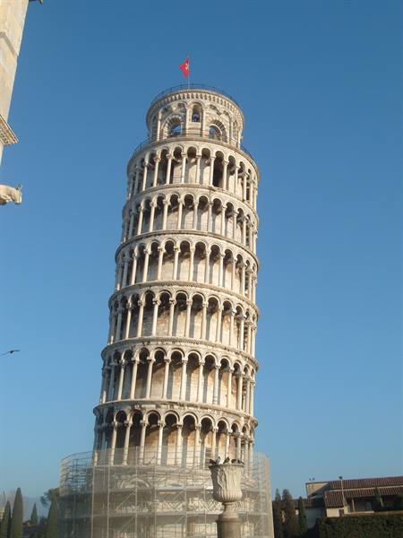 Leaning Tower of Pisa, white marble arcades, morning light, flag on top