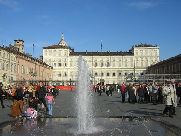 Turin, Piazza Castello: fountain in the foreground, crowds strolling before Palazzo Reale